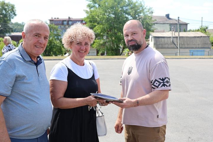 Руслан Олійник вручає ключі та документи на шкільний автобус Олександру Панюті та Наталії Коваленко